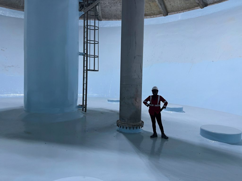 Applicator standing inside a freshly lined water storage tank